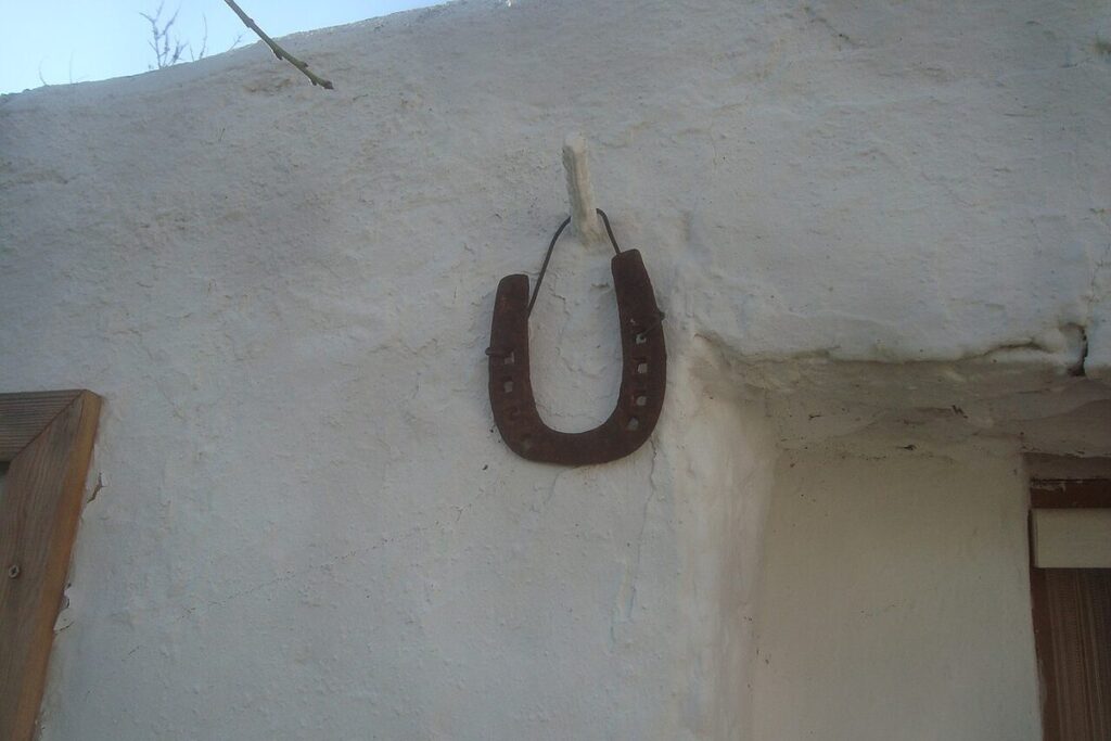Altes Hufeisen an einer weiß getünchten Wand